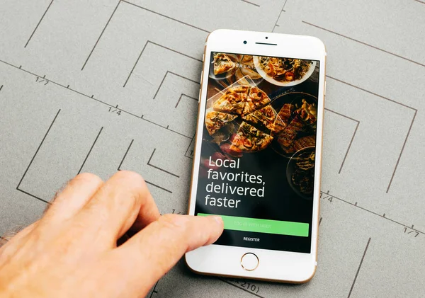Uber съедает доставку еды на iPhone 7 Plus приложением "Война" — стоковое фото