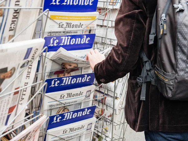 Man buyin Le monde pers krantenkiosk Parijs — Stockfoto