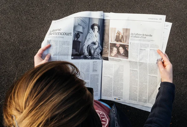 Iew de cima de mulher lendo o mais recente jornal Le Monde com p — Fotografia de Stock