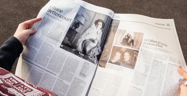 IEW från ovan av kvinna läser senaste tidningen Le Monde med p — Stockfoto