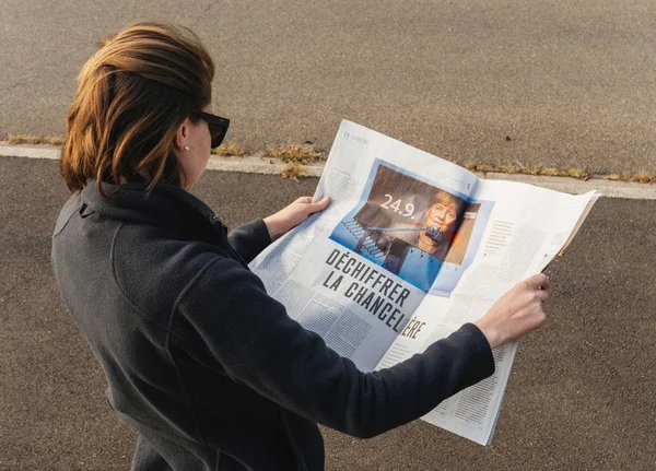Mujer leyendo le Monde Prensa francesa Angela Merkel elections Germ — Foto de Stock