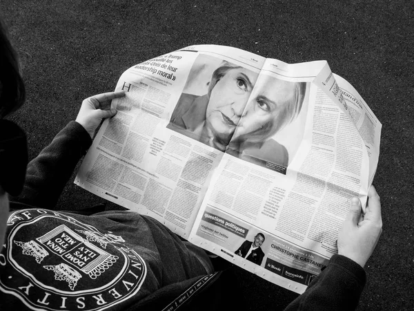 Mulher lendo le Monde Imprensa francesa Hillary Clinton sobre Trump — Fotografia de Stock