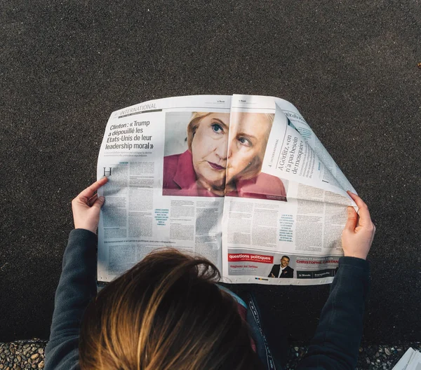 Mujer leyendo Le Monde Prensa francesa Hillary Clinton sobre Trump — Foto de Stock