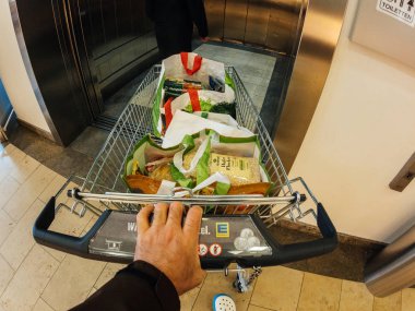 Süpermarket Asansör tam alışveriş sepeti ile giren adam 