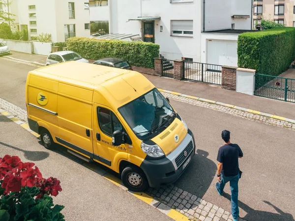 Corriere uomo a piedi verso la Poste furgone consegna giallo — Foto Stock