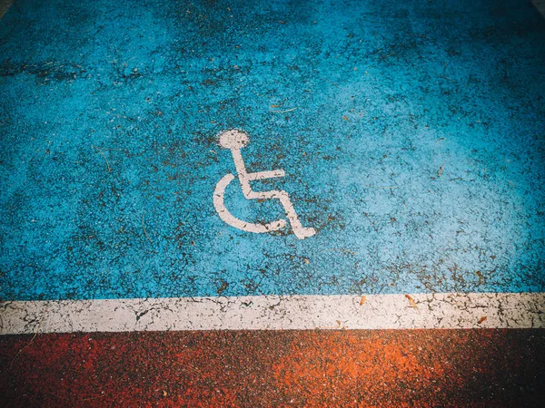 Disabled parking invalide sign painted on the blue asphalt — Stock Photo, Image