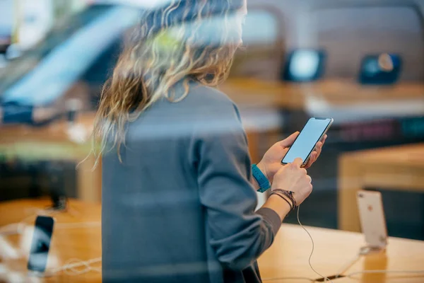 Mujer sosteniendo el último iPhone X dentro de la tienda de manzana — Foto de Stock