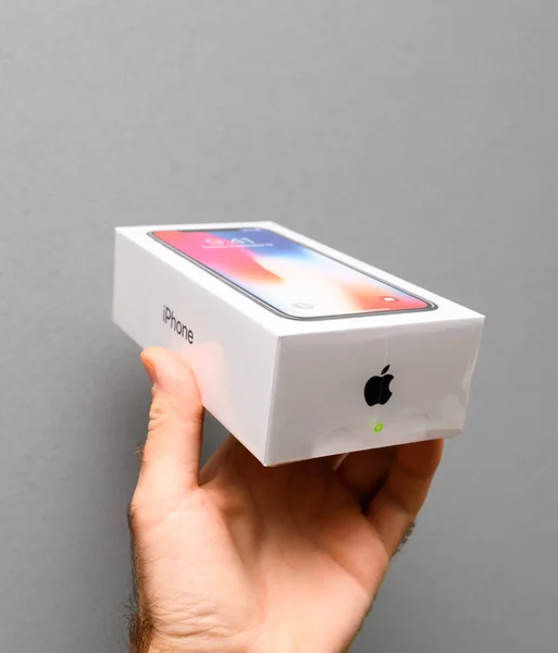 Hombre celebración de Apple iPhone X10 contra fondo gris —  Fotos de Stock