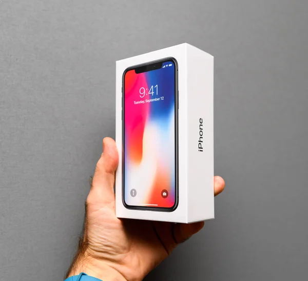 Muž, který držel Apple iphone X10 šedém pozadí — Stock fotografie