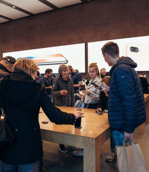 Взрослые и пожилые люди наслаждаются последним Apple iphone X в магазине — стоковое фото