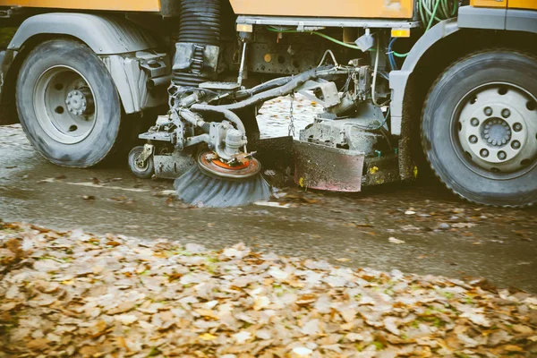 Detail van de wielen van in beweging oranje straat veegmachine — Stockfoto