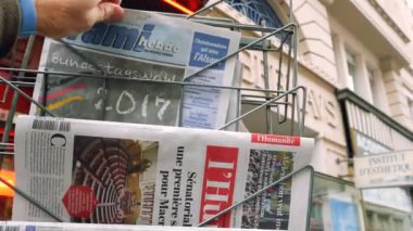 Lyon, Fransa - 10 Nisan 2017: el almak Fransız gazetesi ile sokak arka plan üzerinde Uluslararası Haberler