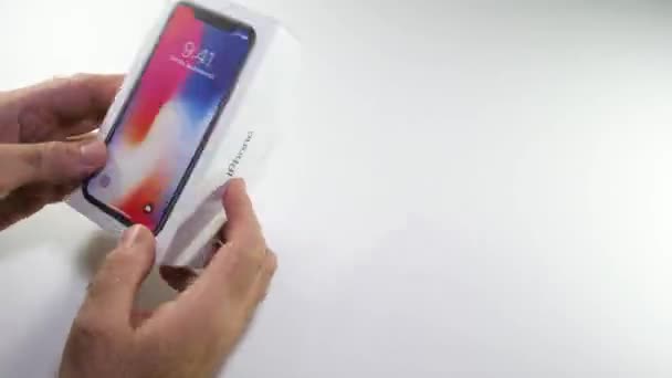 Człowiek unboxing najnowszy iphone Apple X 10 — Wideo stockowe