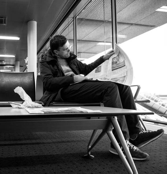 Hombre leyendo en el aeropuerto THe periódico de la revista del New York Times —  Fotos de Stock