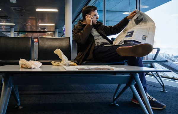 Человек, читающий в аэропорту газету THe New York Times — стоковое фото