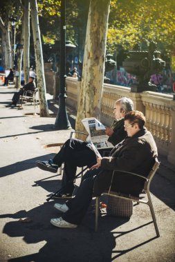 panish senior couple reading La Vanguardia  clipart