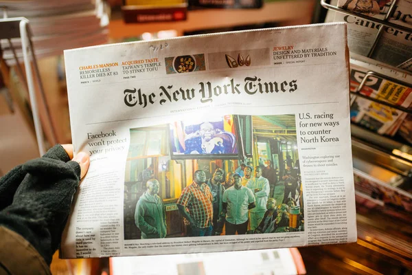 Pov der männlichen Hand mit Handschuhen hält die New York Times mugab — Stockfoto