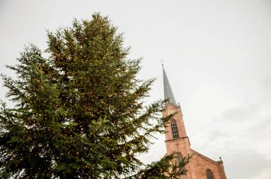 Sarı aydınlatma ve Friedenskir ile görkemli Noel ağacı