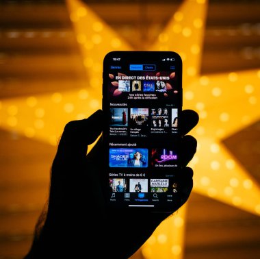 Paris, Fransa - 10 Kasım 2017:, X 10 ekran sarı yıldız bokeh ile yeni Apple iphone tutan adam arka plan featuring dizi ve filmler içinde belgili tanımlık itunes app 