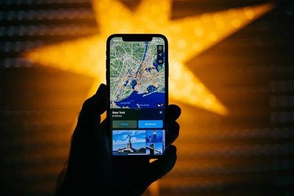 Nový Apple iphone proti modré rozostřeného hvězda nabízí Gps New — Stock fotografie