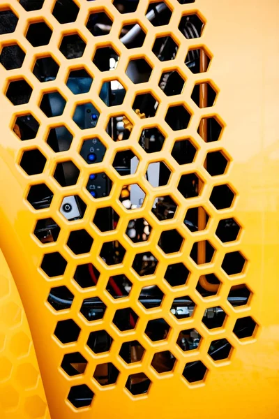 換気と熱い空気の排気のための複数の六角形の形状と黄色に塗られた金属グリル トラクター部分の詳細 — ストック写真