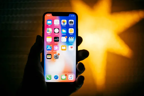 Νέο iphone της Apple ενάντια σε μπλε defocused αστέρι που χαρακτηρίζει το σπίτι εφαρμογές — Φωτογραφία Αρχείου