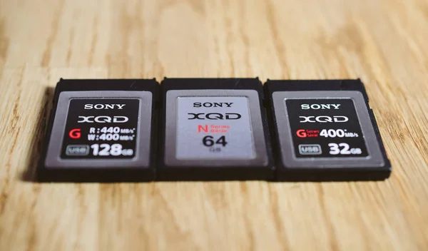 Três novo cartão de memória XQD pela Sony na mesa de madeira — Fotografia de Stock