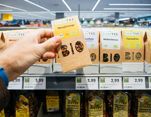 Мужчина покупает в немецком супермаркете традиционный биоорганический чай — стоковое фото