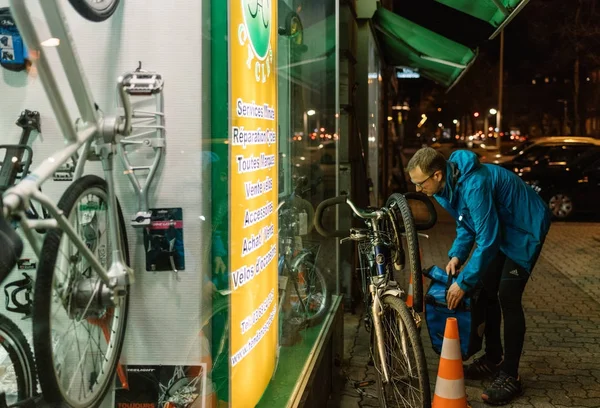 Człowiek pompa koła roweru w Bike przechowywać i — Zdjęcie stockowe