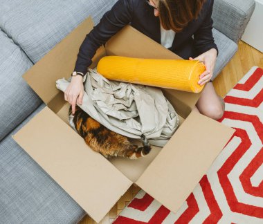 Sarı yoga zen mat tarafından evde beslenen hayvan kedi yardım ediliyor iş kadın/açma unboxing karton kutu kutu içeren güzel hayvan 