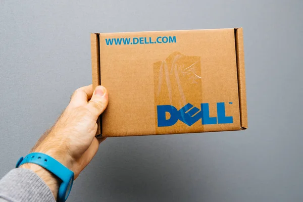 Człowiek posiadający szarym tle tektura z logo firmy Dell — Zdjęcie stockowe