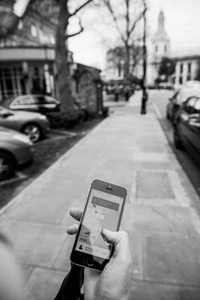 Mujer esperando el coche uber en la calle sosteniendo el teléfono inteligente — Foto de Stock