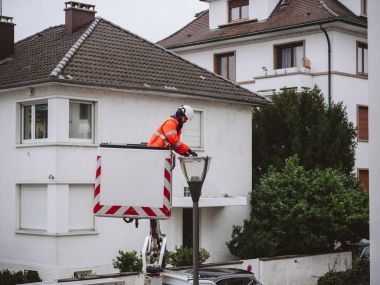 Paris, Fransa - 16 Aralık 2017: Paris'te gece güvenliği için hafif bir direk ve güvenlik içinde belgili tanımlık neighborhood ışık tüp değiştirme tamir temizlik işçisi