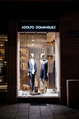 Strasbourg, Fransa - 23 Aralık 2017: Adolfo Dominguez moda mağaza pencere geceleri moda lüks giyim eşyası erkek kadın mankenler ile alışveriş