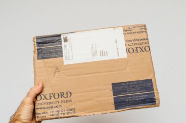 Paris, Fransa - 18 Aralık 2017: Oxford Kütüphane basın Karton Koli beyaz arka plan üzerinde tutan adam 