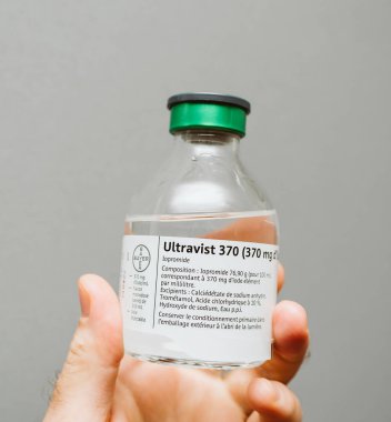 Paris, Fransa - 22 Kasım 2017: Ultravist - Iopromide paket kontrast Ajan ve Ct tarayıcı altında tıbbi müdahale için gerekli tüm aksesuarlar içerir tutan doktor