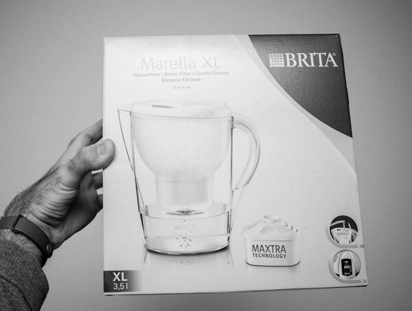 ПАРИЖ, ФРАНЦИЯ - 18 декабря 2017 года: Человек держит новый фильтр воды Brita Marella XL на белом фоне - черно-белое изображение
 