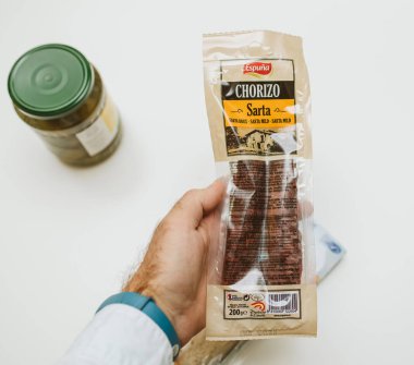 Paris, Fransa - 2 Aralık 2017: Yemek Masası arka plan ile Espuna Chorizo sosis plastik bir şişe tutan adam