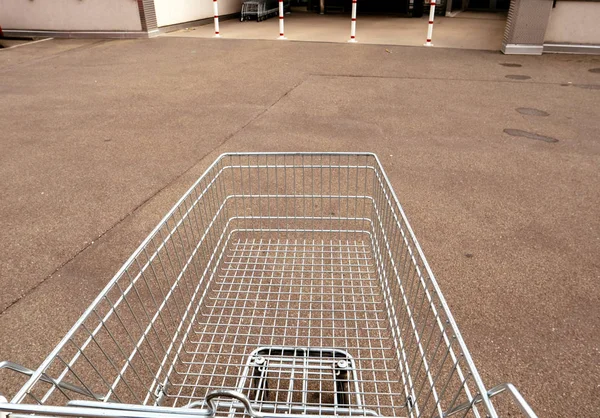 Empujar el coche del supermercado a la entrada del supermercado — Foto de Stock