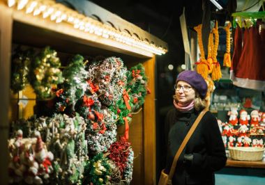 Geleneksel Noel Pazar Strasbourg Alsace Fransa, Noel çelenk hayran trendy moda bere şapka giyen güzel Fransız gülümseyen kadın portresi