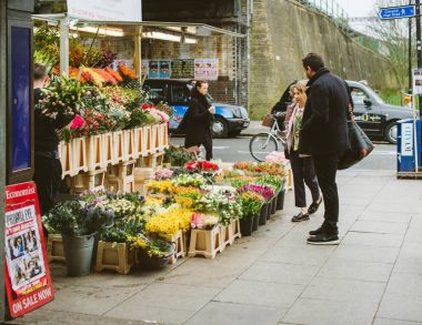 London, Büyük Britanya - 10 Mart 2017: Çift çiçek çiçek çiçekçi kiosk Londra Caddesi üzerinde sabah erken alıyor