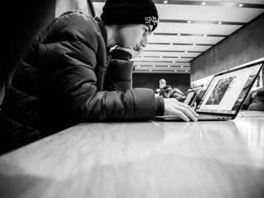 Apple Macbook pro retina dizüstü bilgisayarda okuma meraklı genç çocuk