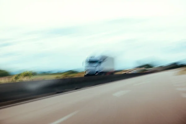 Концептуальний силует дефокованої вантажівки в русі на шосе — стокове фото