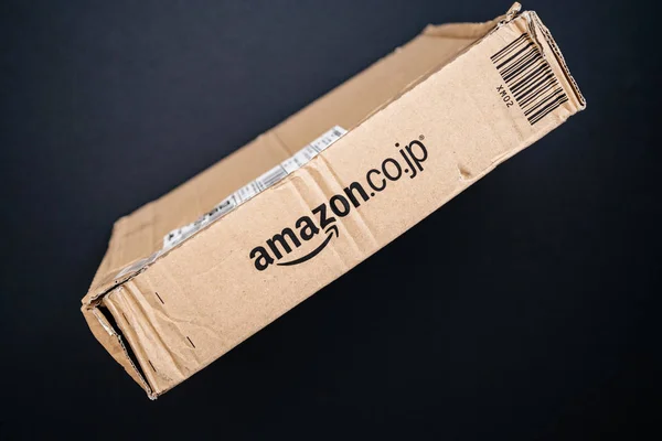 Amazon japan paket auf schwarzem hintergrund mit amazon.co.jp log — Stockfoto