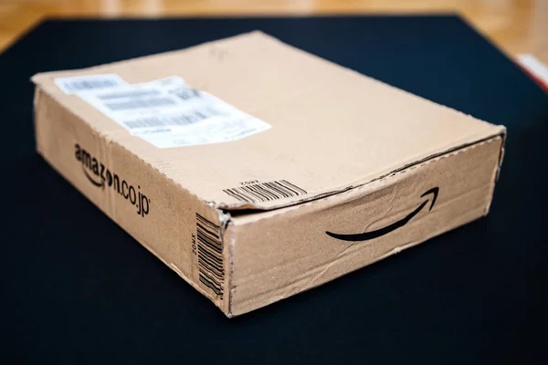 Amazon japan paket auf schwarzem hintergrund mit amazon.co.jp log — Stockfoto