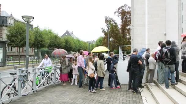 Pessoas esperando na fila para entrar na sinagoga em um dia chuvoso — Vídeo de Stock