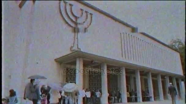 Menschen, die an einem regnerischen Tag Schlange stehen, um die Synagoge zu betreten — Stockvideo