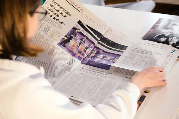 Mujer leyendo el periódico Le Monde con debate presidencial francés — Foto de Stock