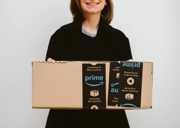 Lächelnde Frau mit Amazon Prime-Paket-Karton — Stockfoto