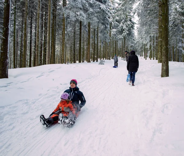 Winter day with snow and happy mother and doughter sleighing the — Stock Photo, Image